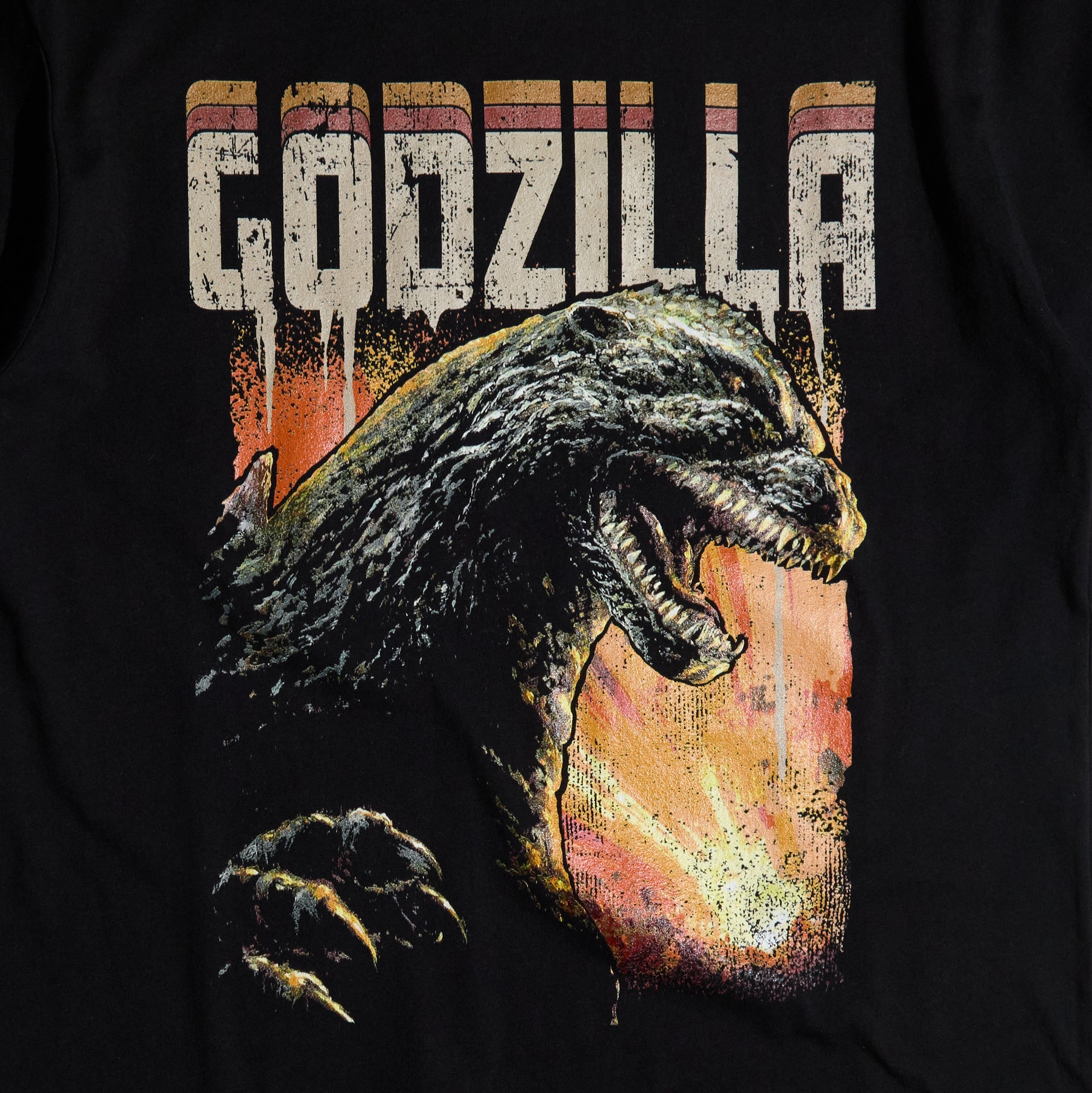 Close-up of the graphics on Black T-shirt featuring a roaring Godzilla with a fiery background and distressed "Godzilla" text.